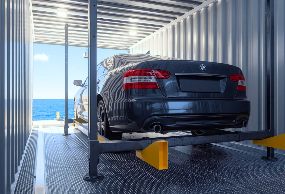 A used car securely positioned inside a steel shipping container on a raised racking system, with the ocean visible through the open doors, illustrating safe, efficient, and sustainable containerised car transport.