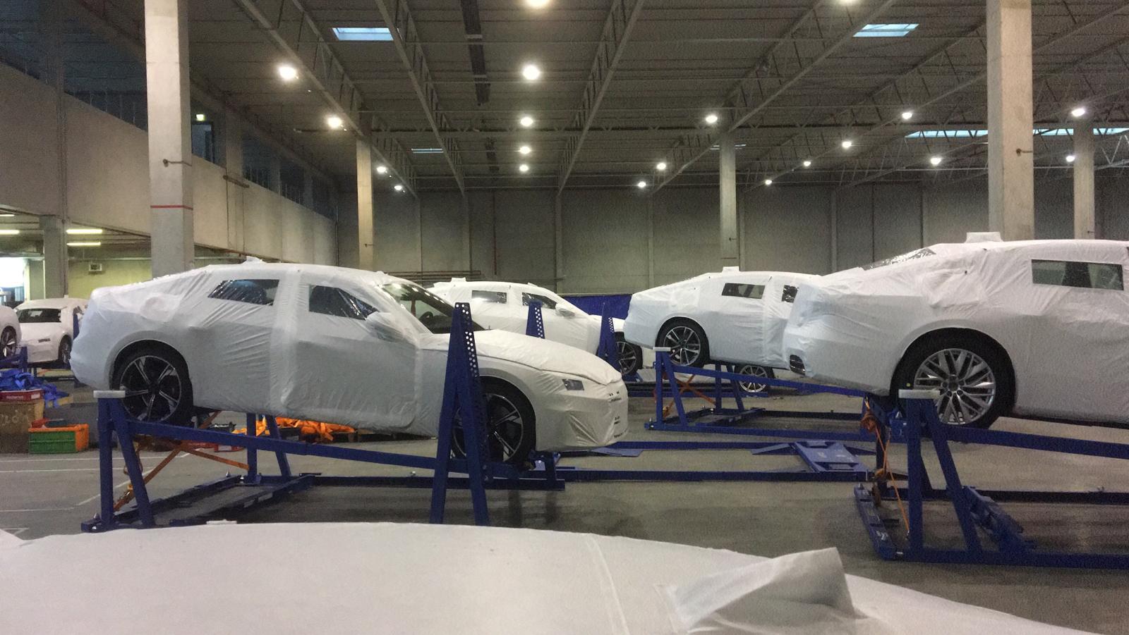 Finished vehicle racking system demonstrating efficient automotive storage and transport amid rising shipping costs in a logistics warehouse.