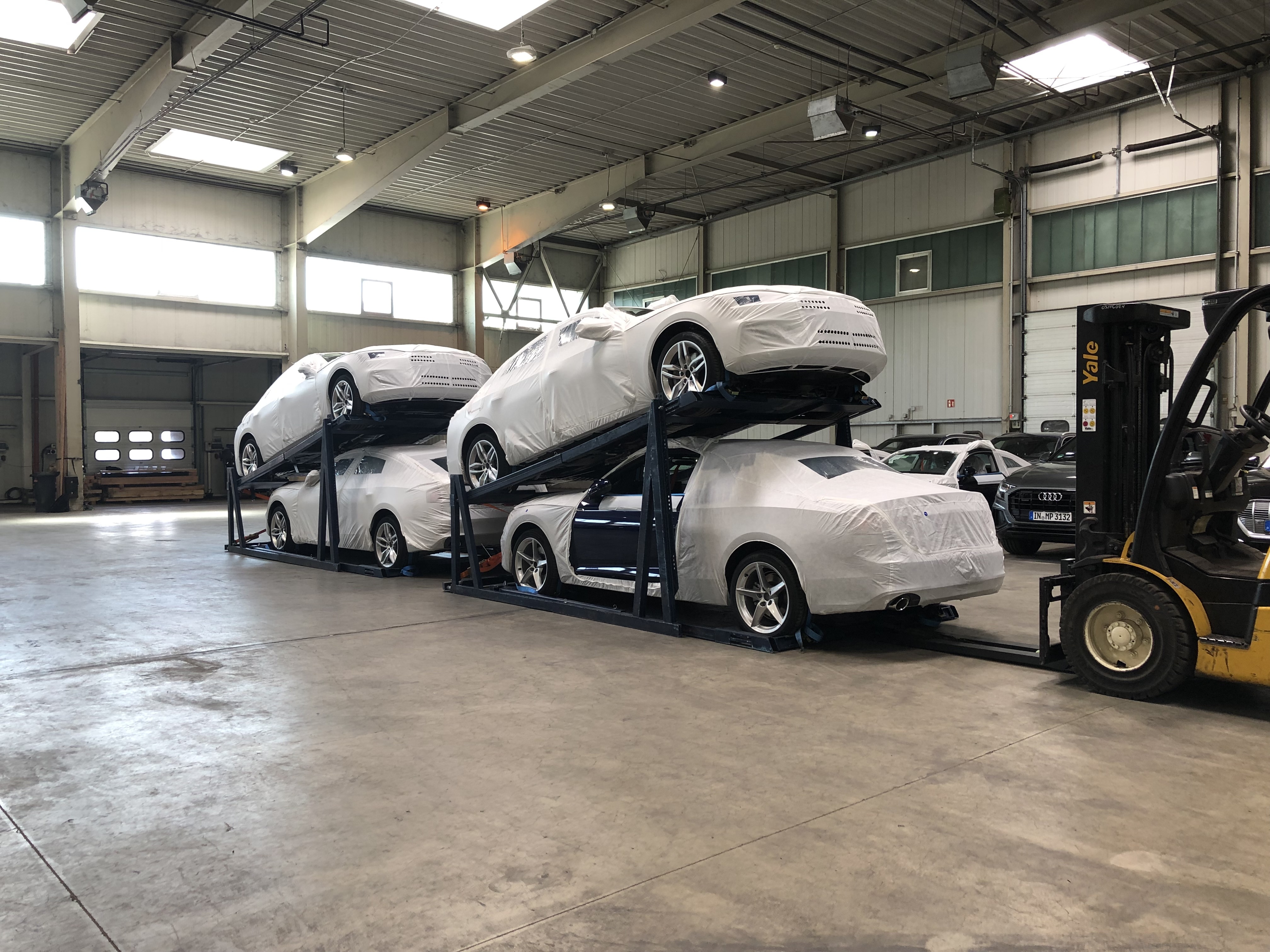 Vehicles being loaded into shipping containers, representing car containerisation and global automotive transport cost analysis.