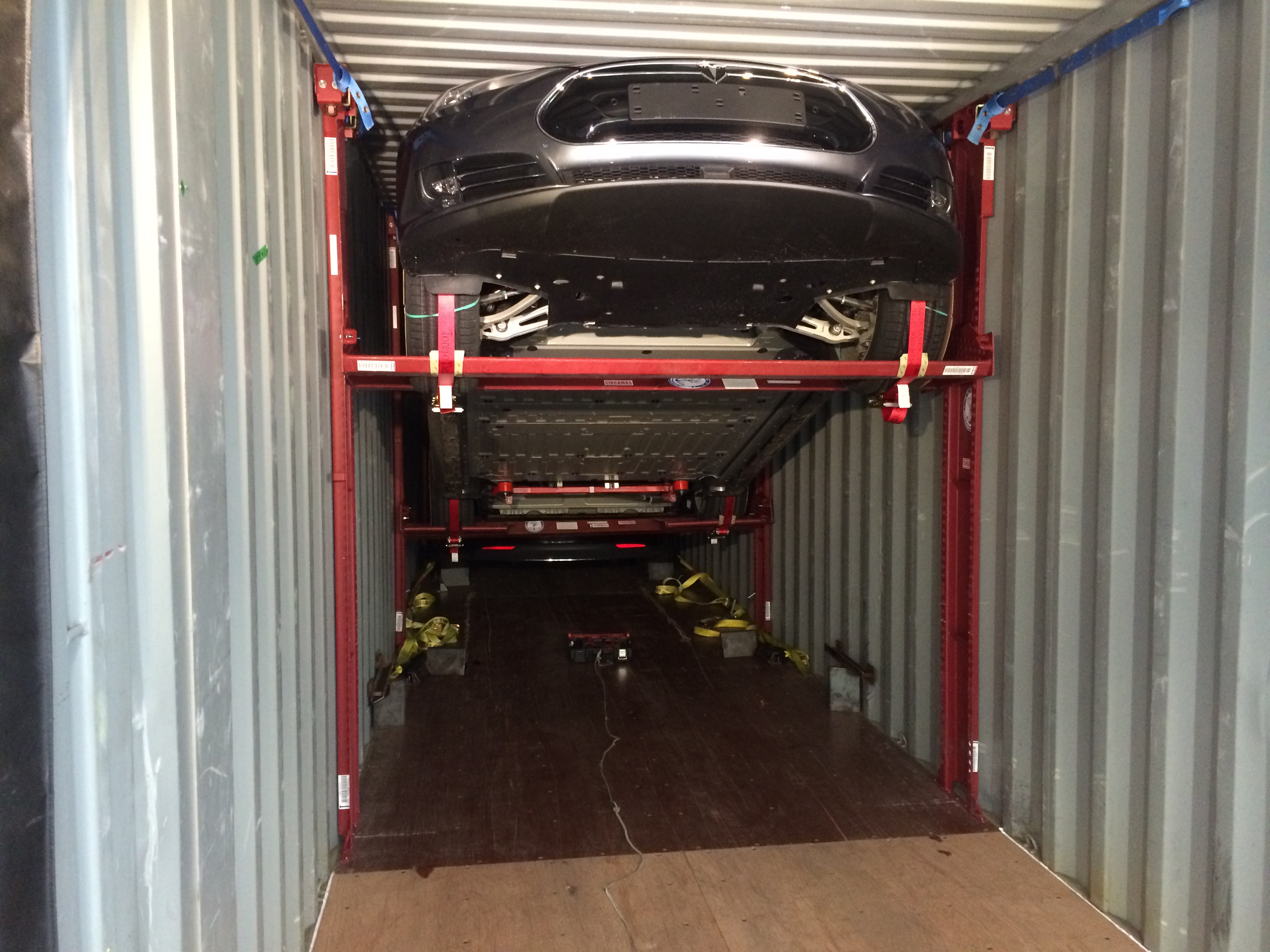 car being lifted on a racking system inside a shipping container to show how to ship UN 3171 classified battery powered vehicles